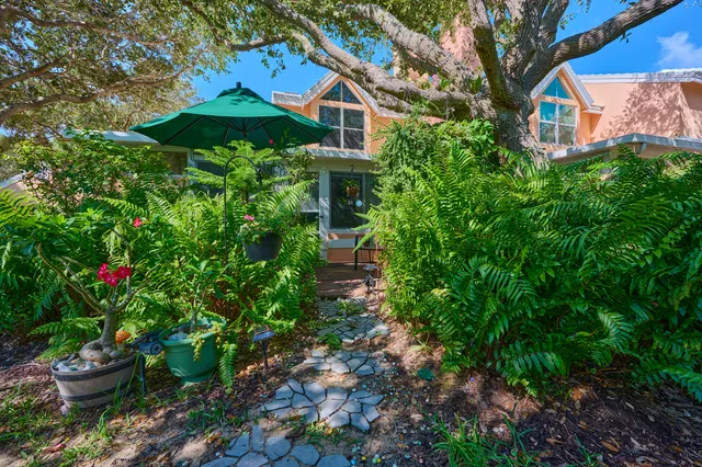 a backyard of a house with table and chairs potted plants