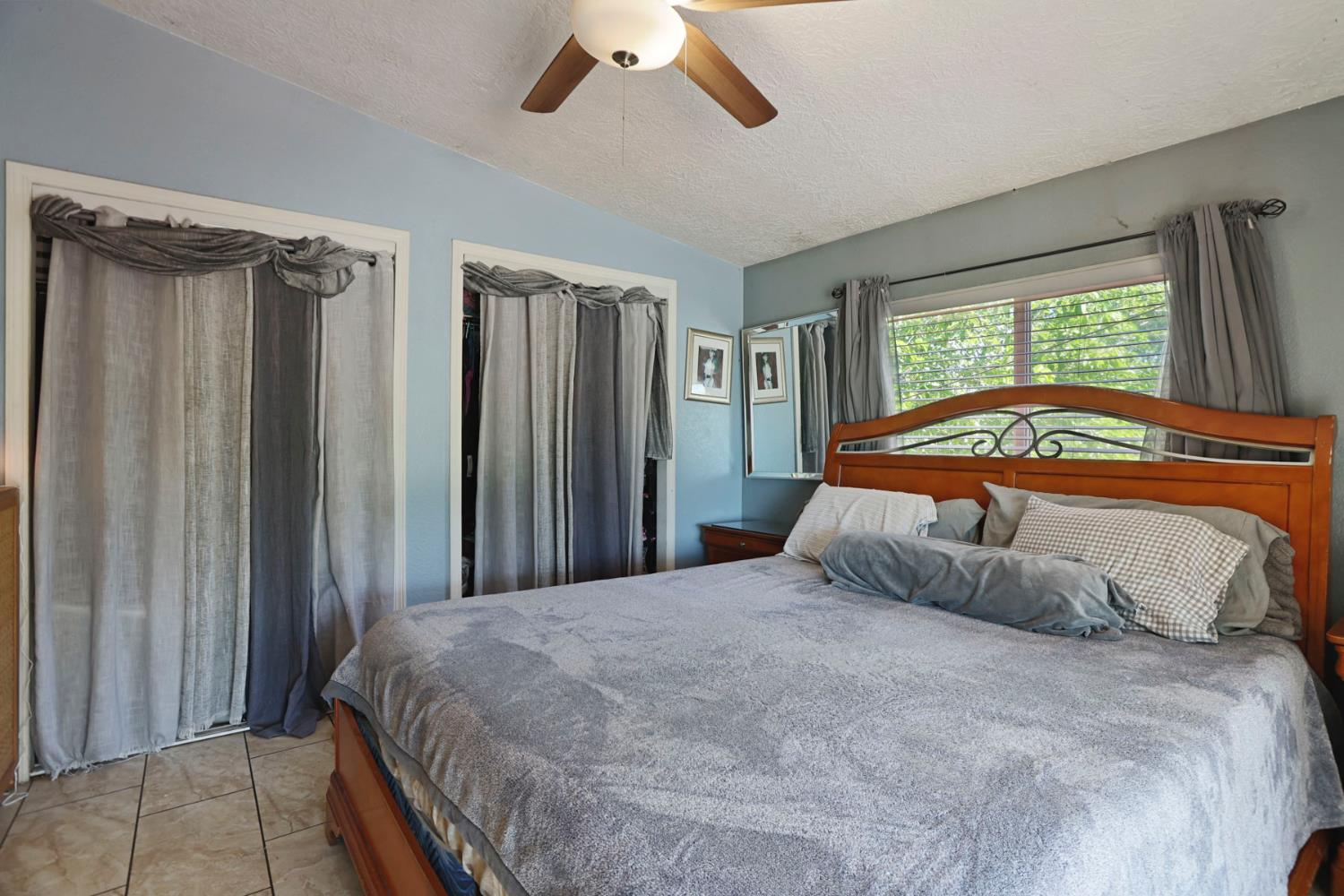 901 Quail Oaks Road Valley Springs, CA 95252 - Photo 16 of 59 a bedroom with a large bed and a chandelier