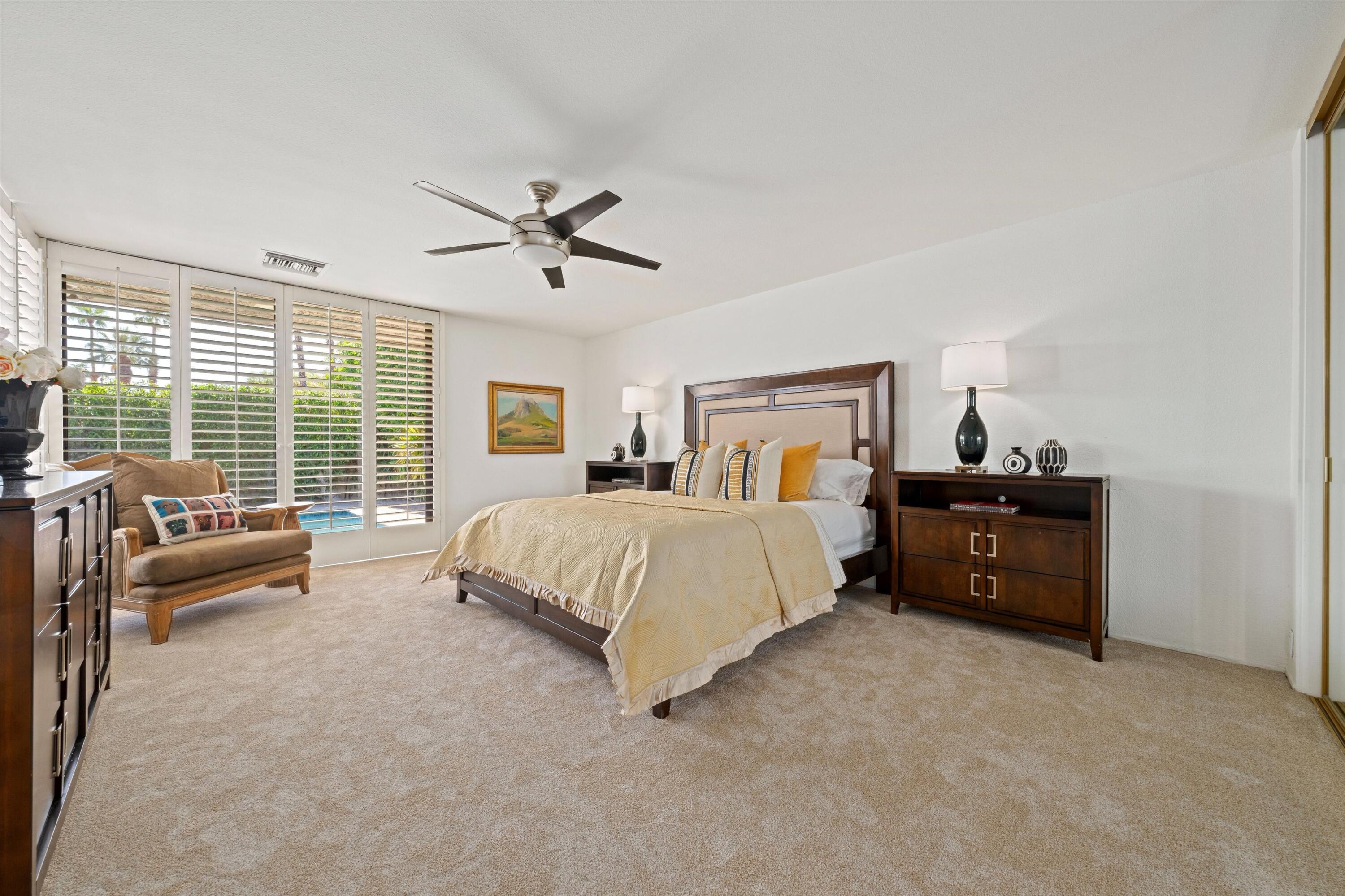 75 Colgate Drive Rancho Mirage, CA 92270 - Photo 19 of 40 a spacious bedroom with a bed a couch and a large window