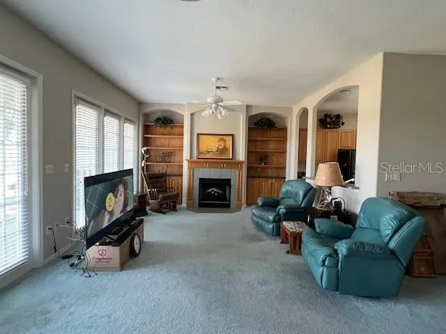 a living room with furniture a fireplace and a chandelier