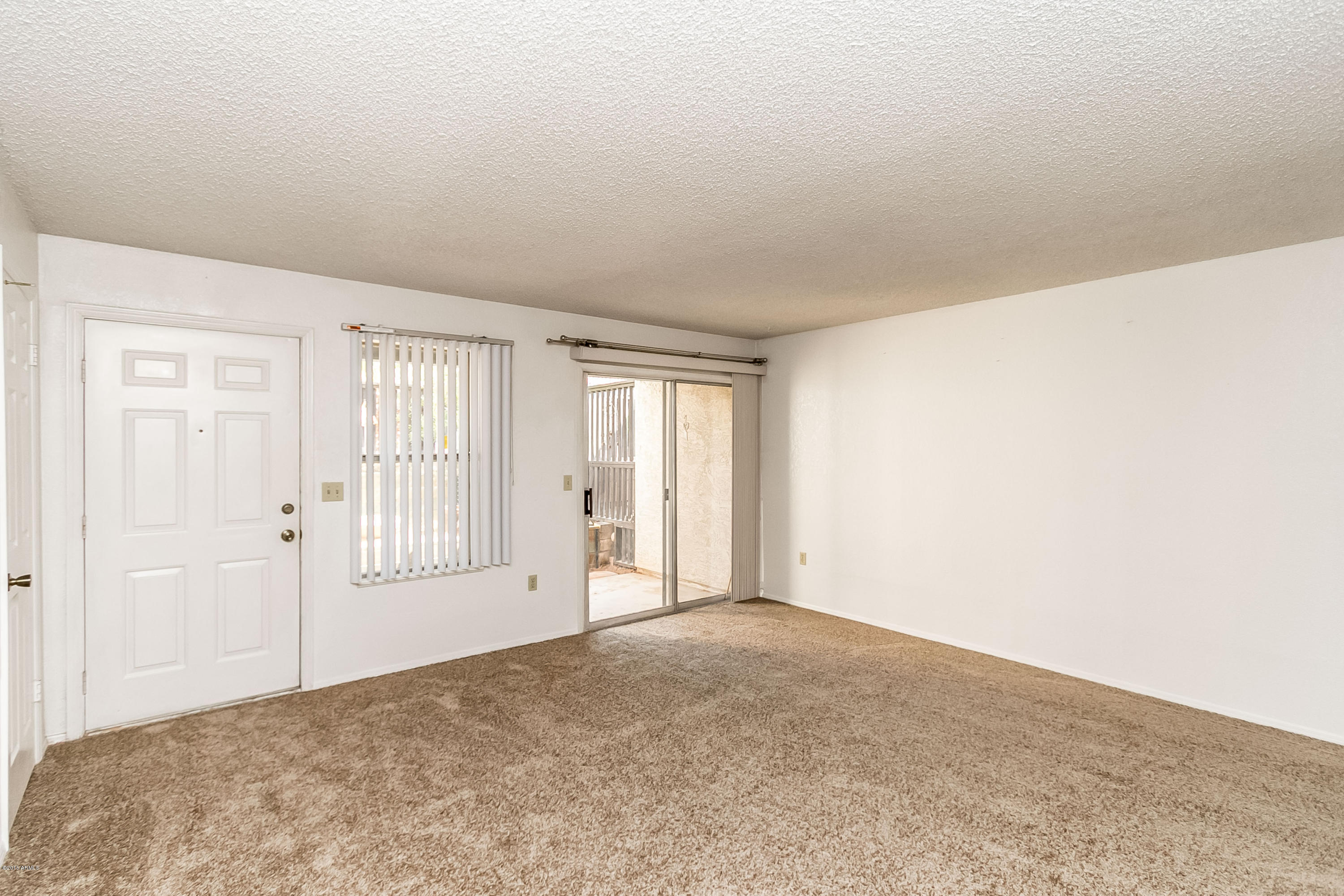 1645 West Baseline Road, Unit 1160 Mesa, AZ 85202 - Photo 4 of 27 a view of an empty room with wooden floor and a window