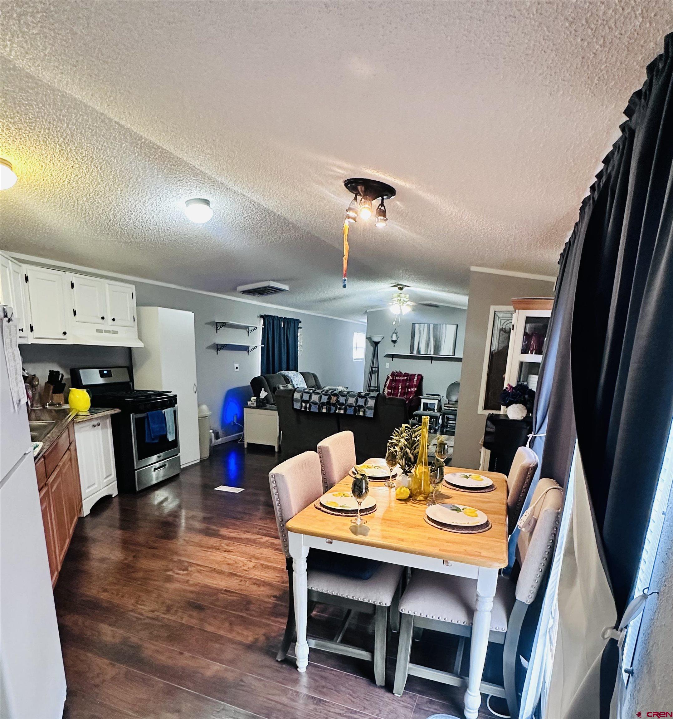 62880 Lasalle Road, Unit 174 Montrose, CO 81401 - Photo 13 of 23 a view of a dining room with furniture and wooden floor
