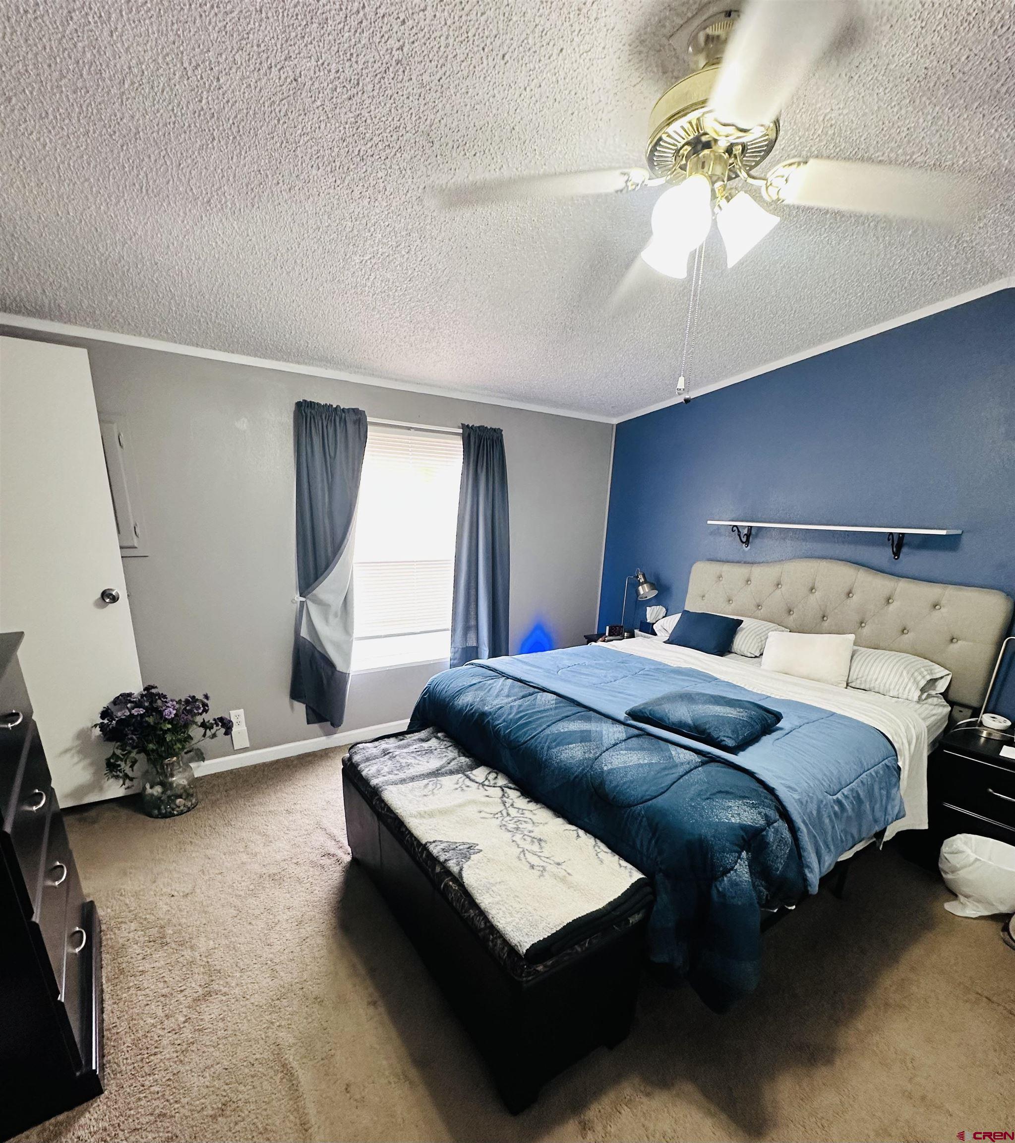 62880 Lasalle Road, Unit 174 Montrose, CO 81401 - Photo 17 of 23 a bedroom with a bed and a chandelier