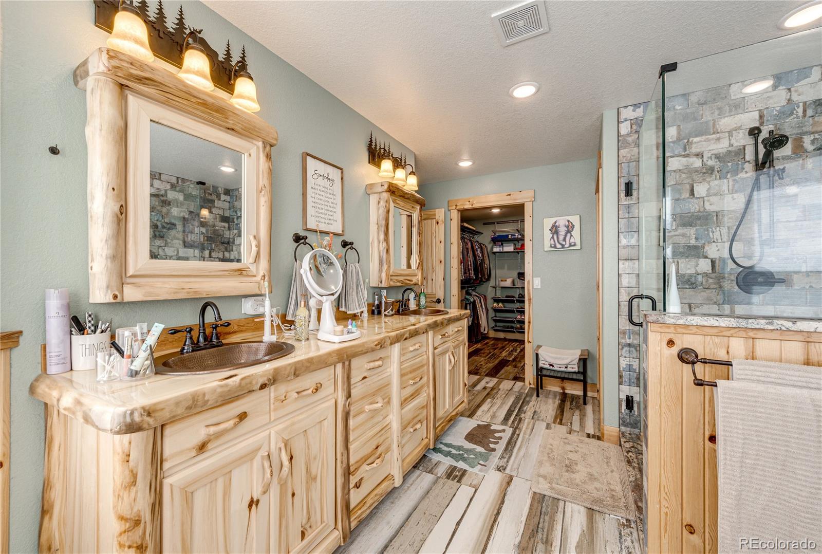 3955 South Behrens Road Byers, CO 80103 - Photo 16 of 32 a spacious bathroom with a double vanity sink a mirror and a shower
