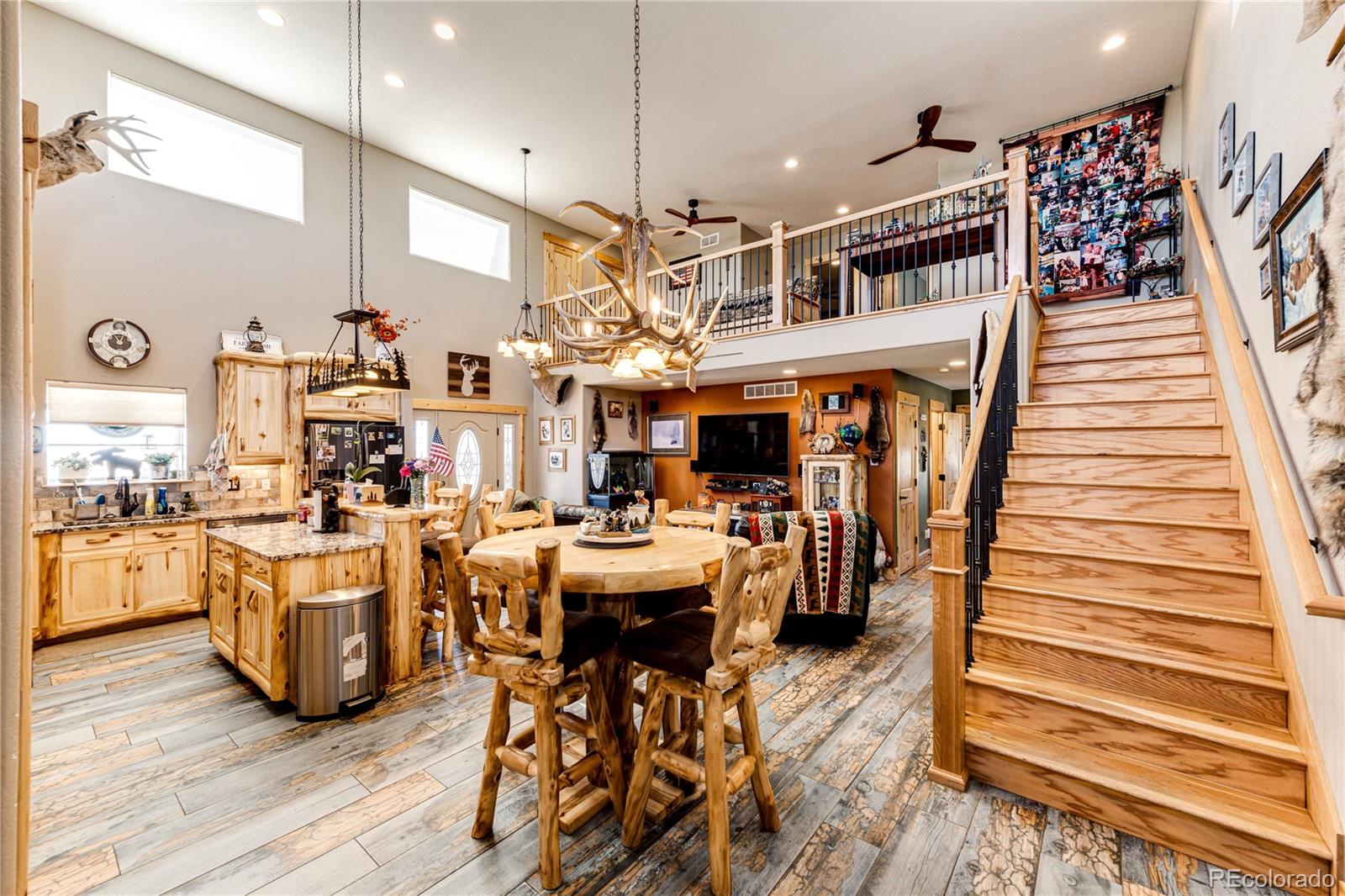 3955 South Behrens Road Byers, CO 80103 - Photo 8 of 32 a view of a living room and kitchen with furniture wooden floor and chandelier