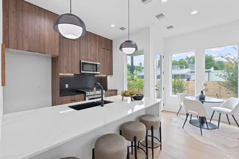 a kitchen with a dining table chairs sink and granite counter top