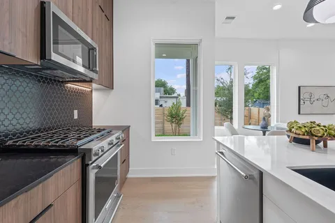 a kitchen that has a sink a stove and a wooden cabinets