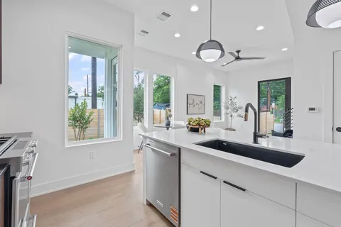 a kitchen with stainless steel appliances a large island in the center and a large window