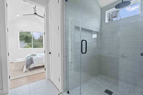 a bathroom with a tub shower and window
