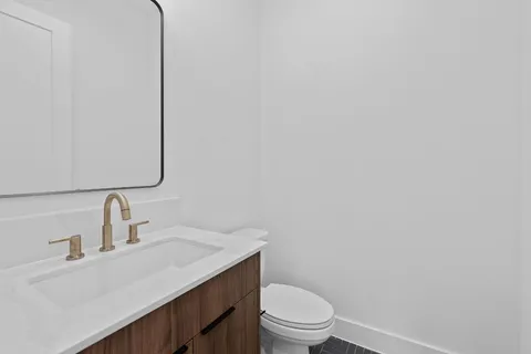 a bathroom with a sink a toilet and mirror