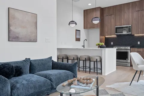 a living room with furniture and a dining table