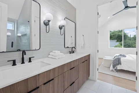 a bathroom with a double vanity sink mirror and bathtub