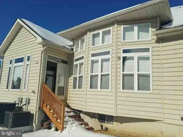 a view of a house with a small space and wooden deck