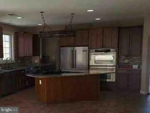 a kitchen with kitchen island granite countertop a sink stainless steel appliances and cabinets