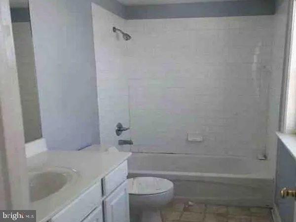 a bathroom with a granite countertop toilet a sink and bathtub