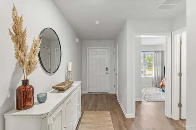 a hallway with view of bathroom and mirror
