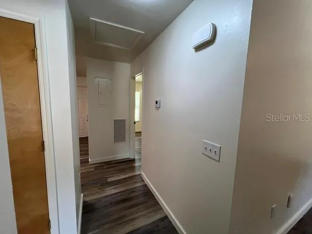 a view of a hallway with wooden floor and staircase