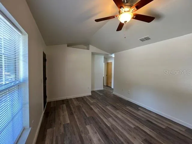 a view of empty room with wooden floor