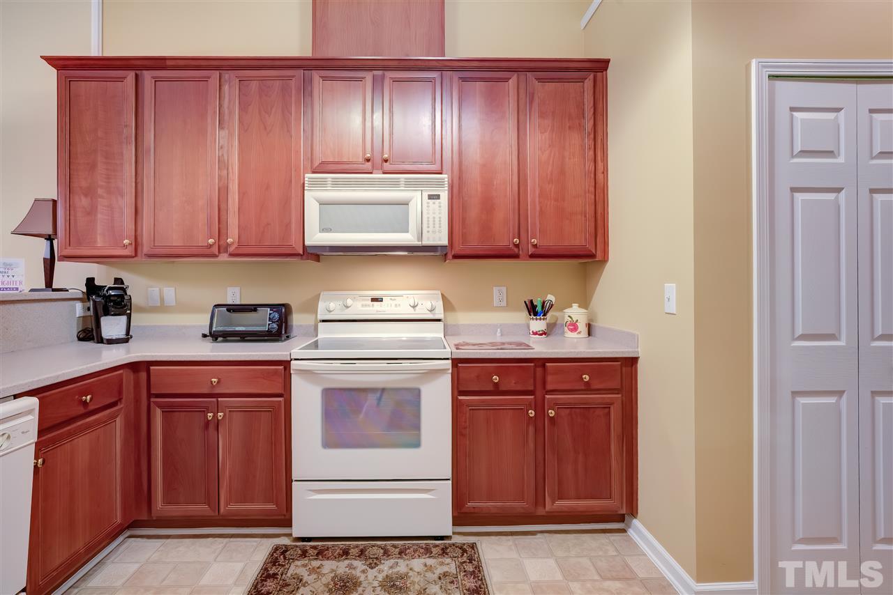 10305 Dapping Drive Raleigh, NC 27614 - Photo 13 of 30 a kitchen with a sink dishwasher stove and cabinets