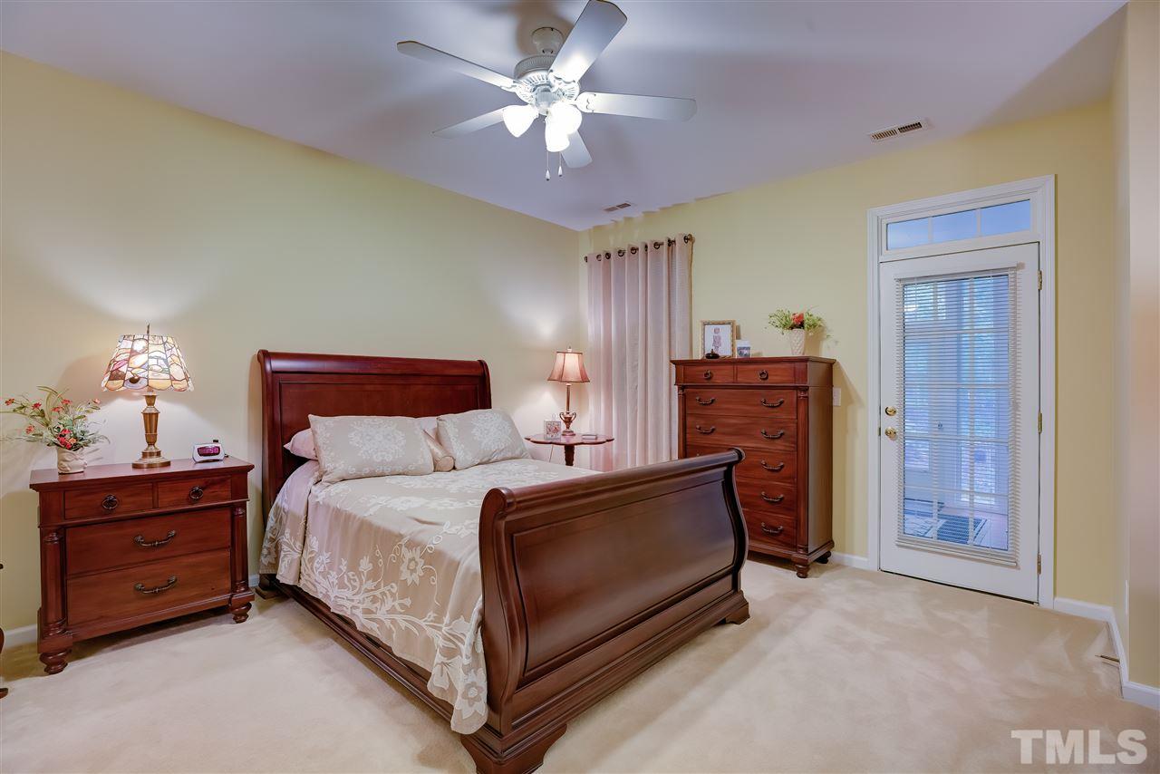 10305 Dapping Drive Raleigh, NC 27614 - Photo 16 of 30 a bedroom with a bed and a chandelier