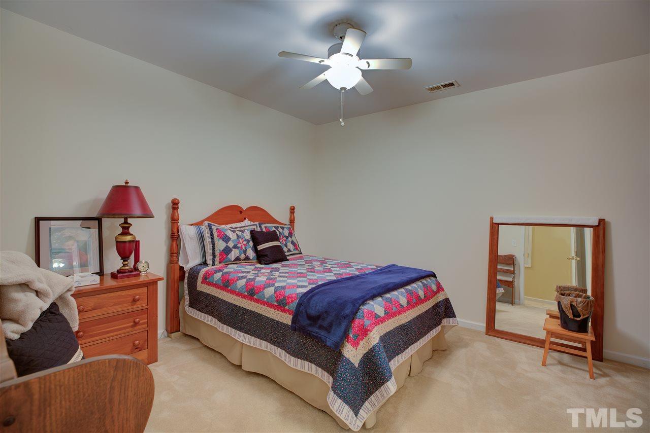10305 Dapping Drive Raleigh, NC 27614 - Photo 25 of 30 a bedroom with a bed and a chandelier