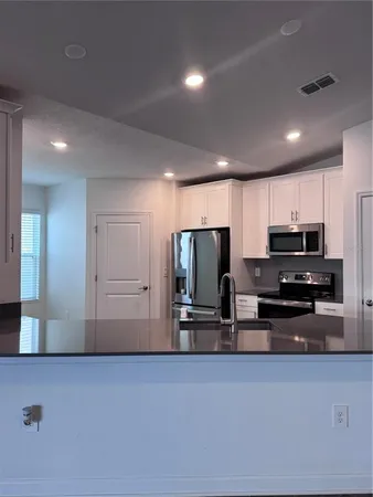 a kitchen with stainless steel appliances a refrigerator and a stove top oven