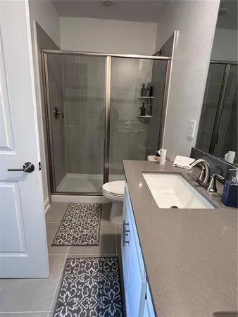 a bathroom with a sink a toilet a mirror and shower