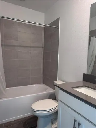 a white toilet sitting next to a bath tub