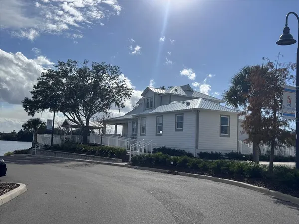 a front view of a house with a garden and trees