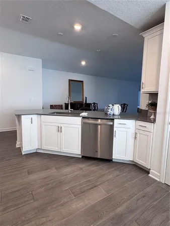 a white kitchen with a sink and white cabinets