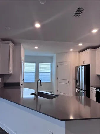a kitchen with stainless steel appliances granite countertop a sink a stove and a refrigerator
