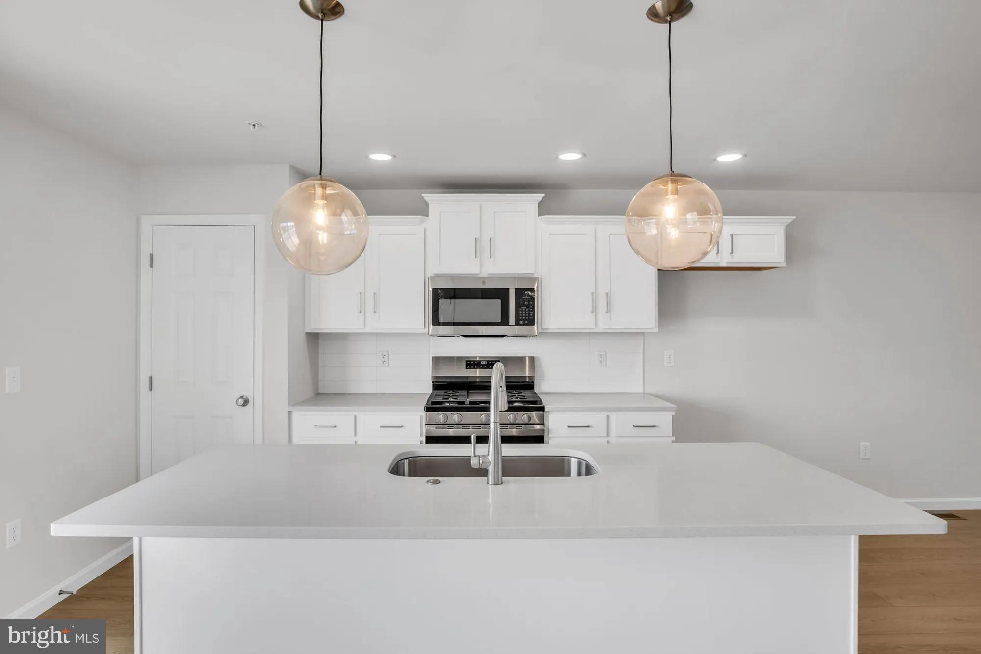 4 Morgan Circle, Unit 1303 Carlisle, PA 17013 - Photo 2 of 13 a kitchen with stainless steel appliances granite countertop a sink a stove and a chandelier