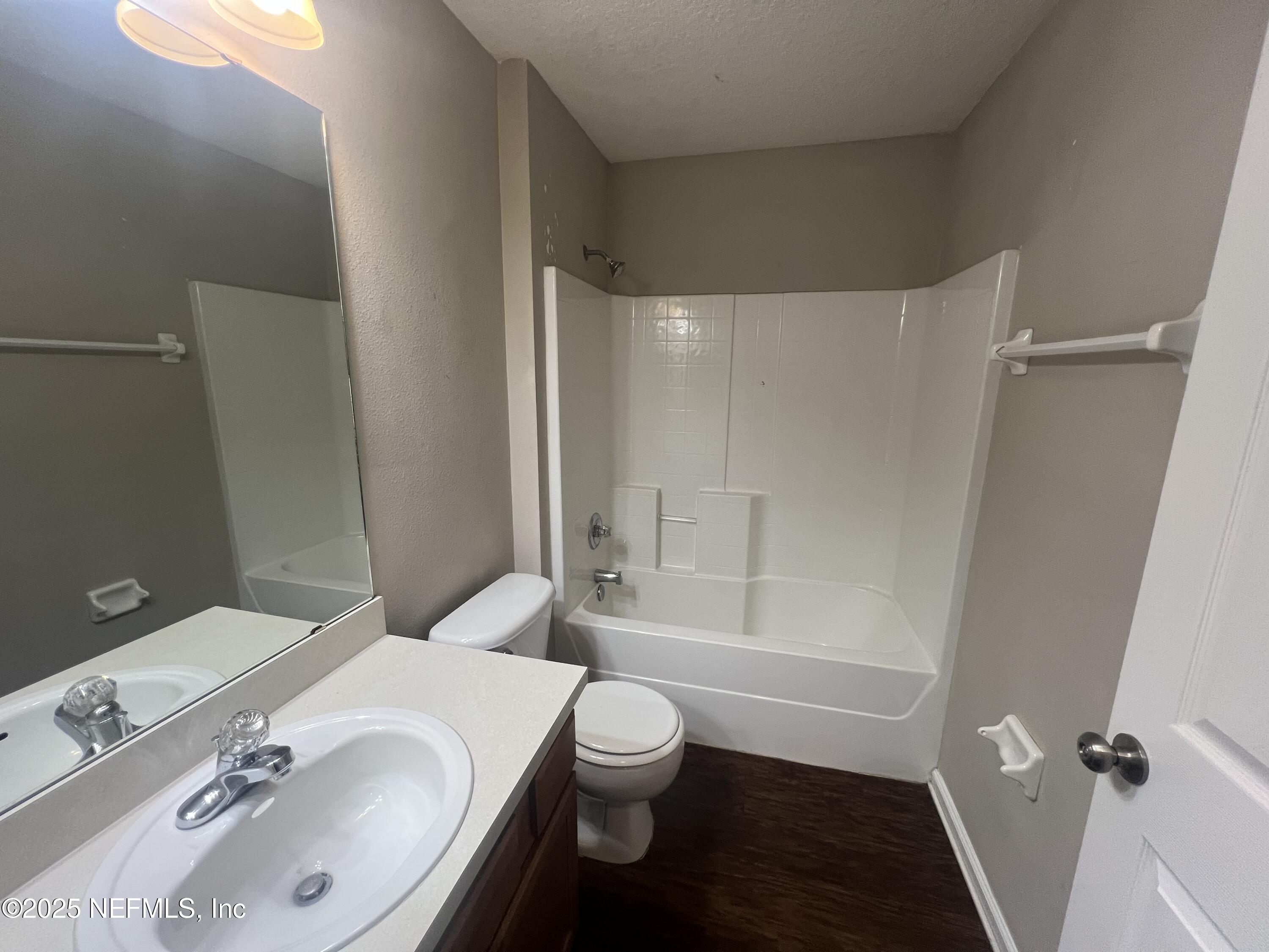 1960 McGirts Point Boulevard Jacksonville, FL 32221 - Photo 15 of 18 a bathroom with a granite countertop sink toilet a mirror and shower