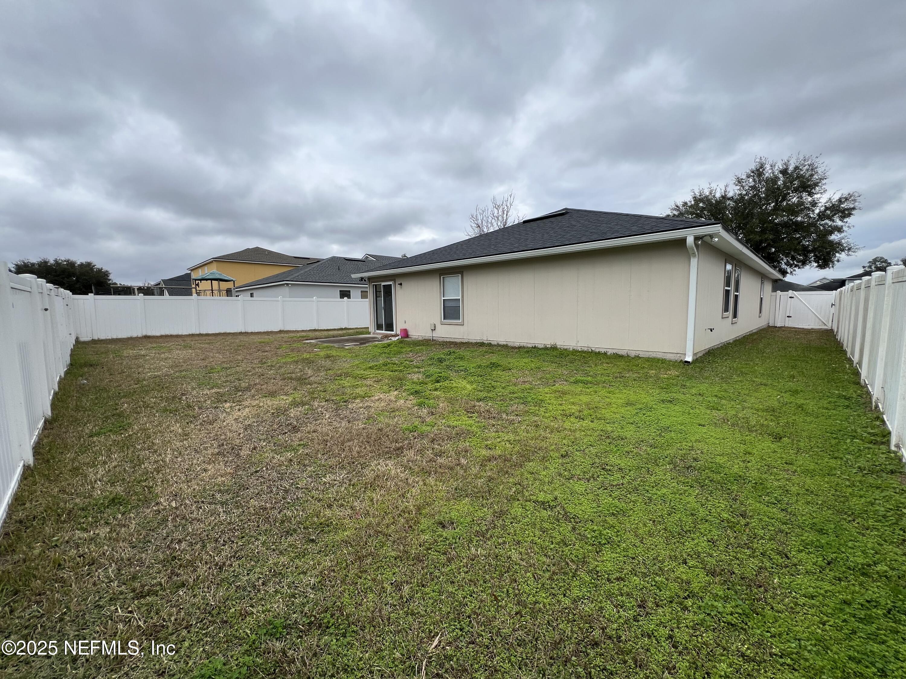 1960 McGirts Point Boulevard Jacksonville, FL 32221 - Photo 16 of 18 a tall white house with a yard and wooden fence