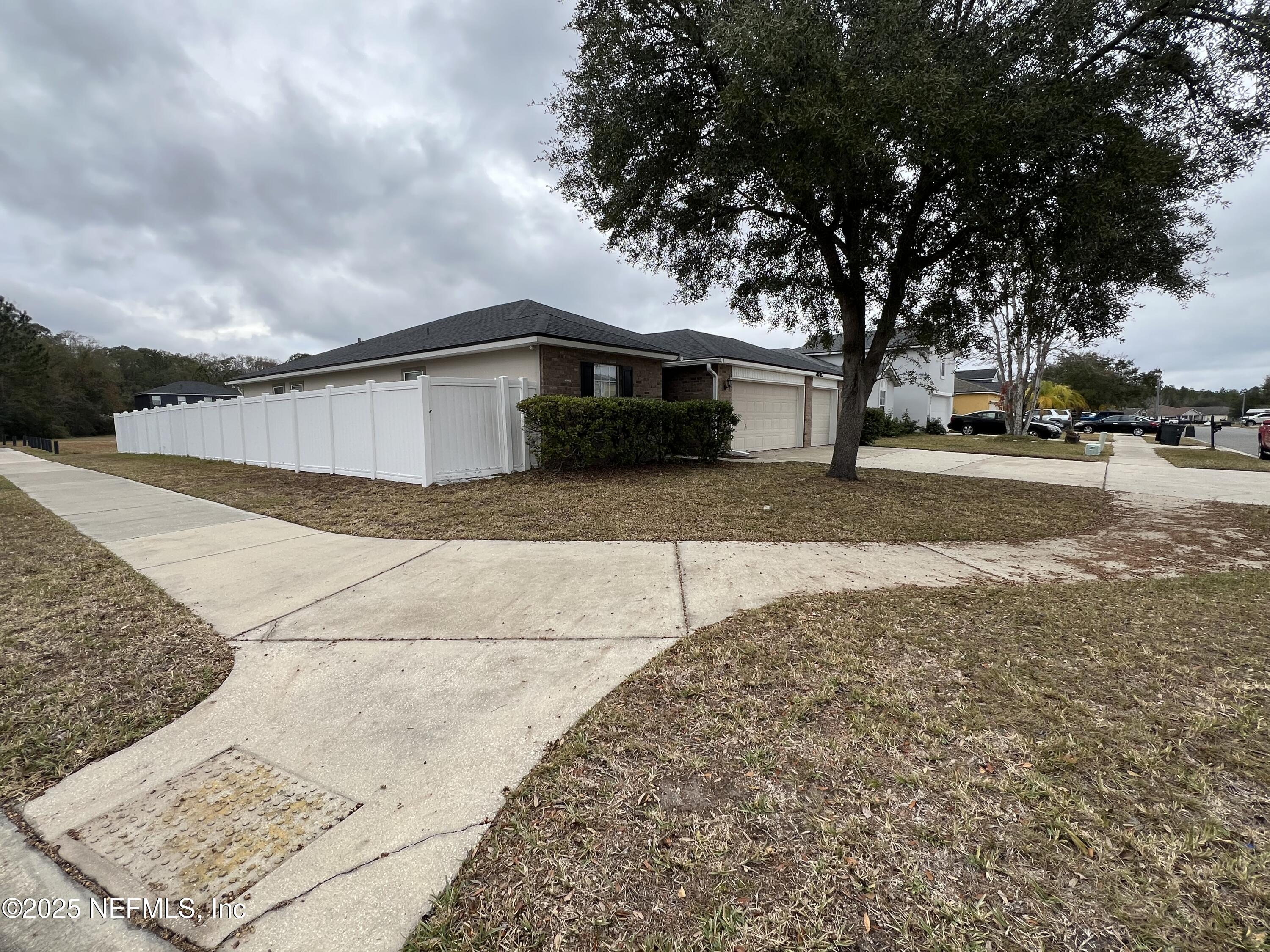 1960 McGirts Point Boulevard Jacksonville, FL 32221 - Photo 2 of 18 a front view of a house with a yard and garage