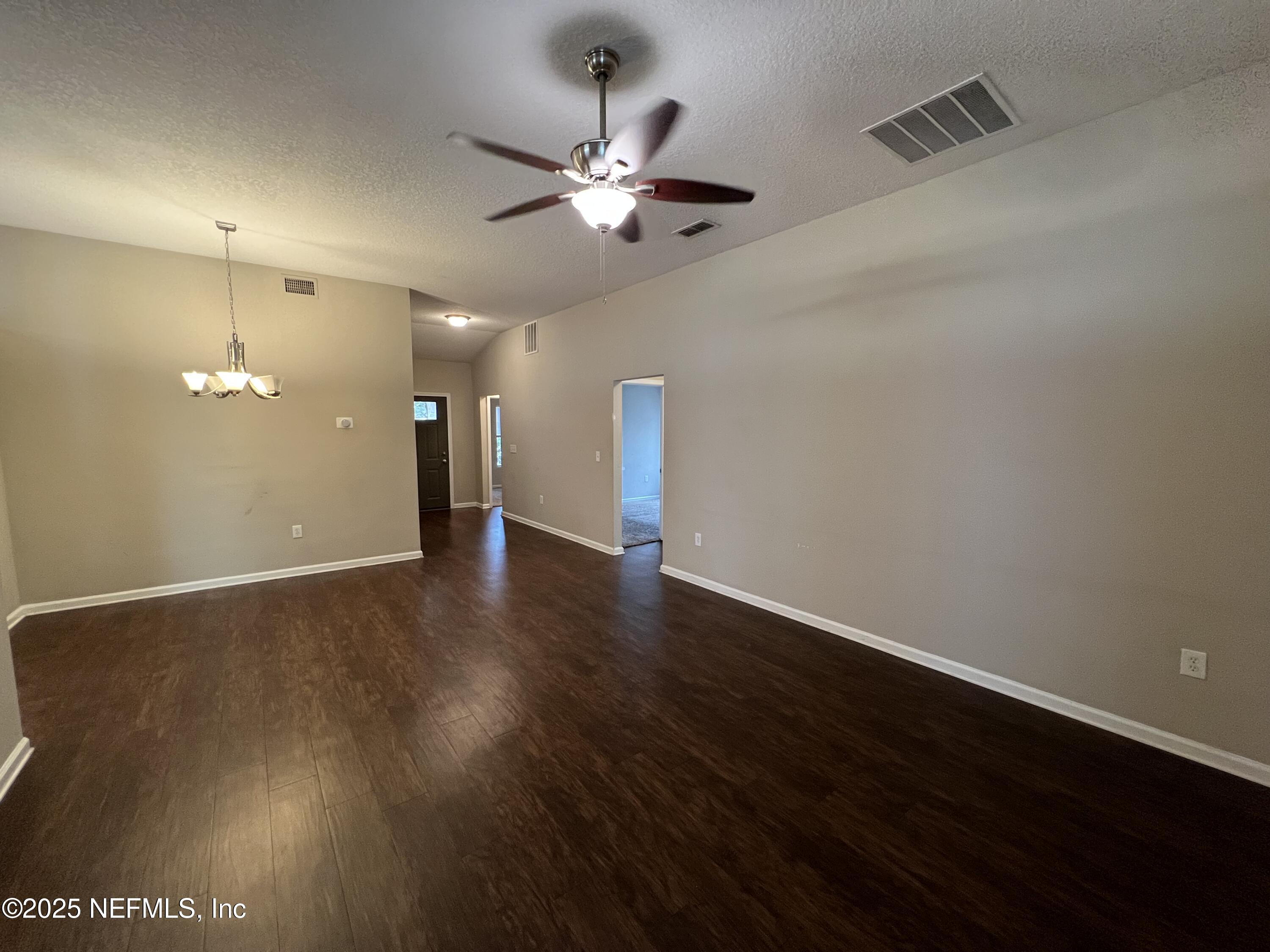 1960 McGirts Point Boulevard Jacksonville, FL 32221 - Photo 4 of 18 an empty room with wooden floor and chandelier fan