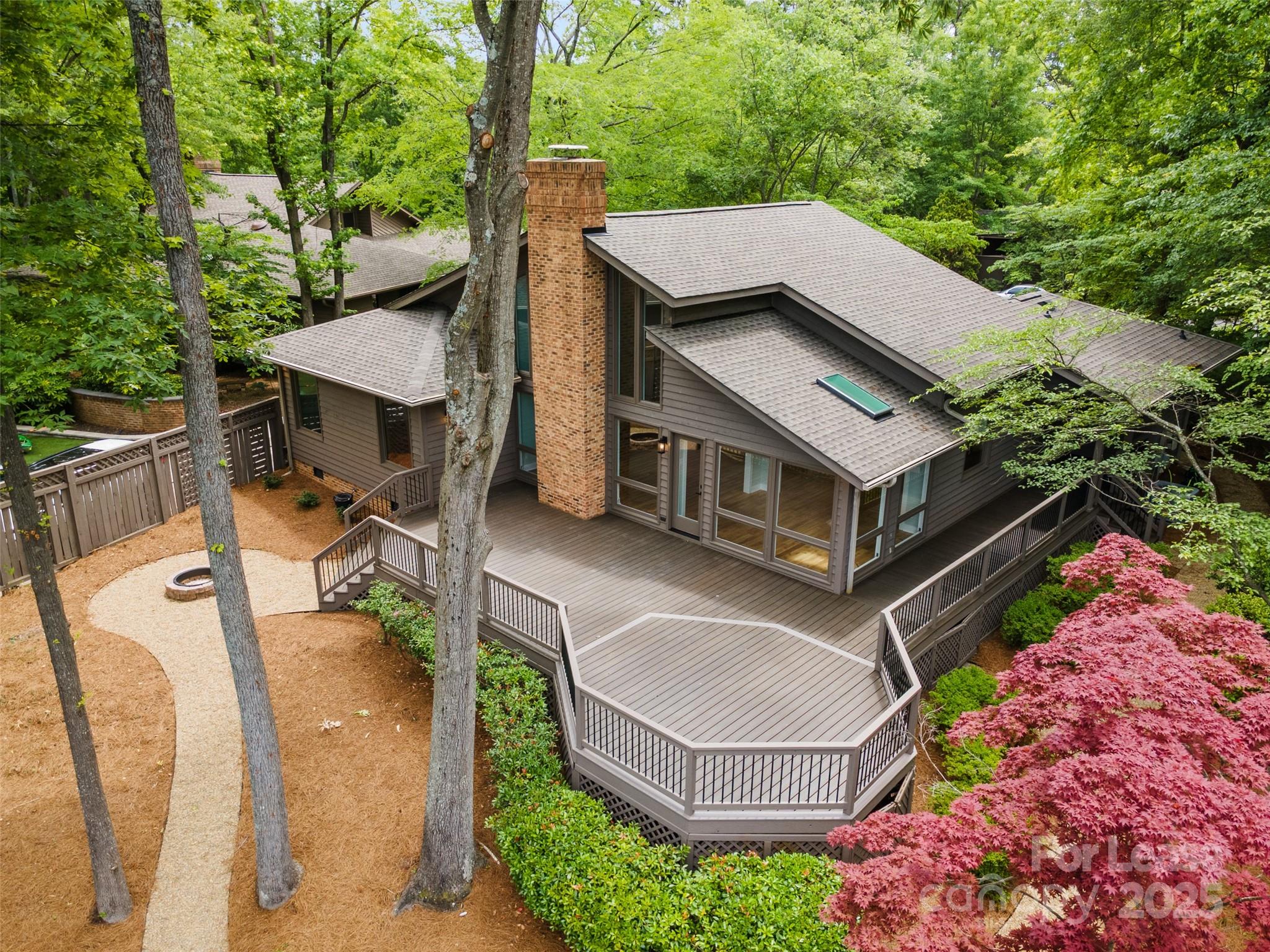 an aerial view of a house with swimming pool and trees