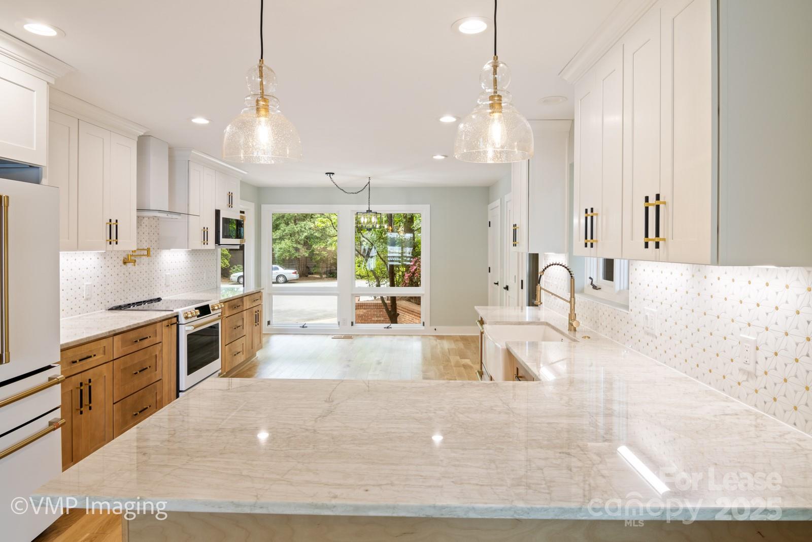 449 Windward Drive Davidson, NC 28036 - Photo 12 of 46 a large kitchen with kitchen island a large counter top a sink stainless steel appliances and cabinets