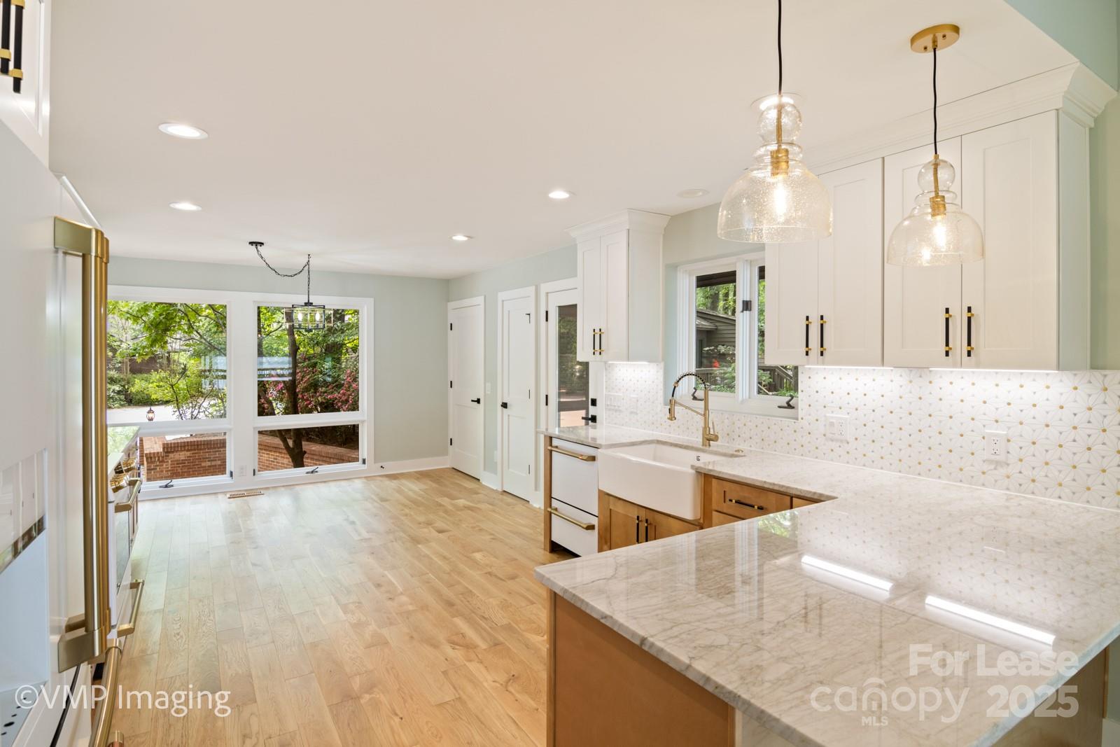 449 Windward Drive Davidson, NC 28036 - Photo 13 of 46 a large kitchen with kitchen island a large counter top stainless steel appliances and windows