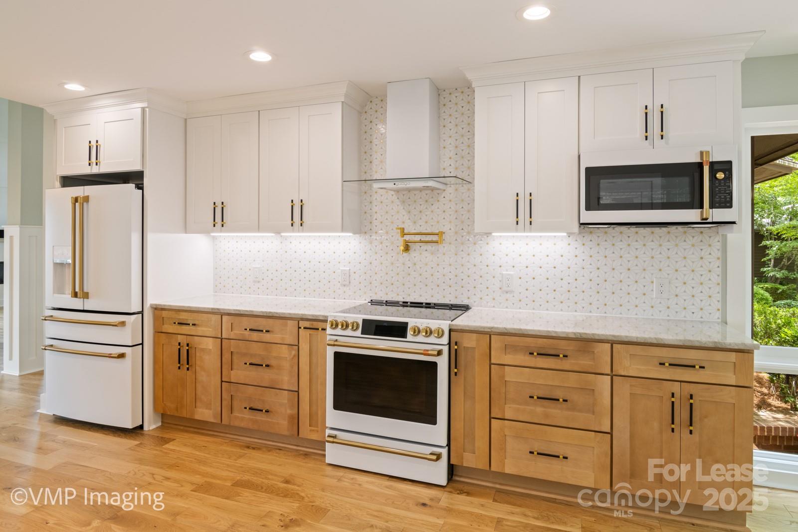 449 Windward Drive Davidson, NC 28036 - Photo 15 of 46 a kitchen with white cabinets and stainless steel appliances