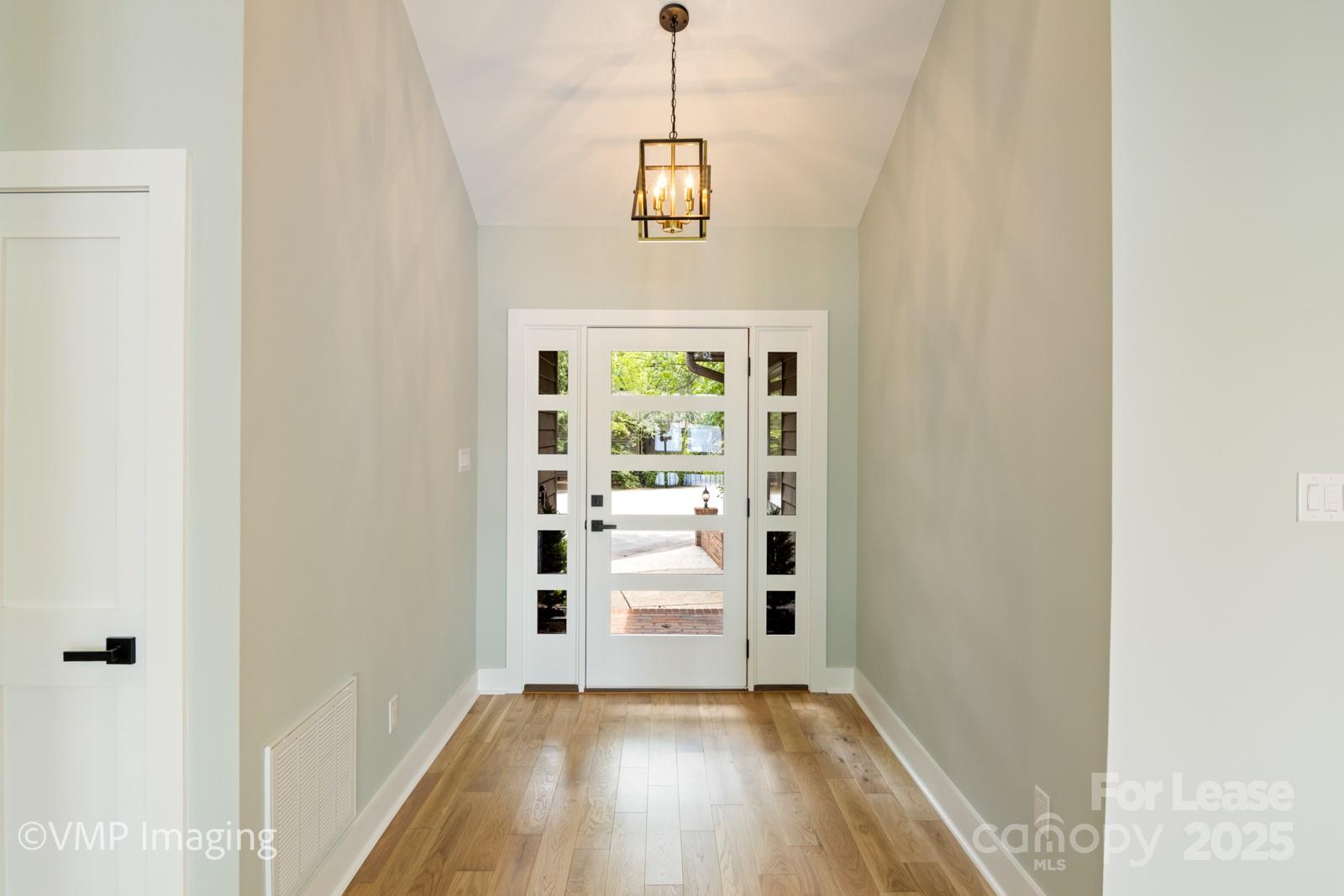 449 Windward Drive Davidson, NC 28036 - Photo 19 of 46 a view of hallway with stairs and wooden floor