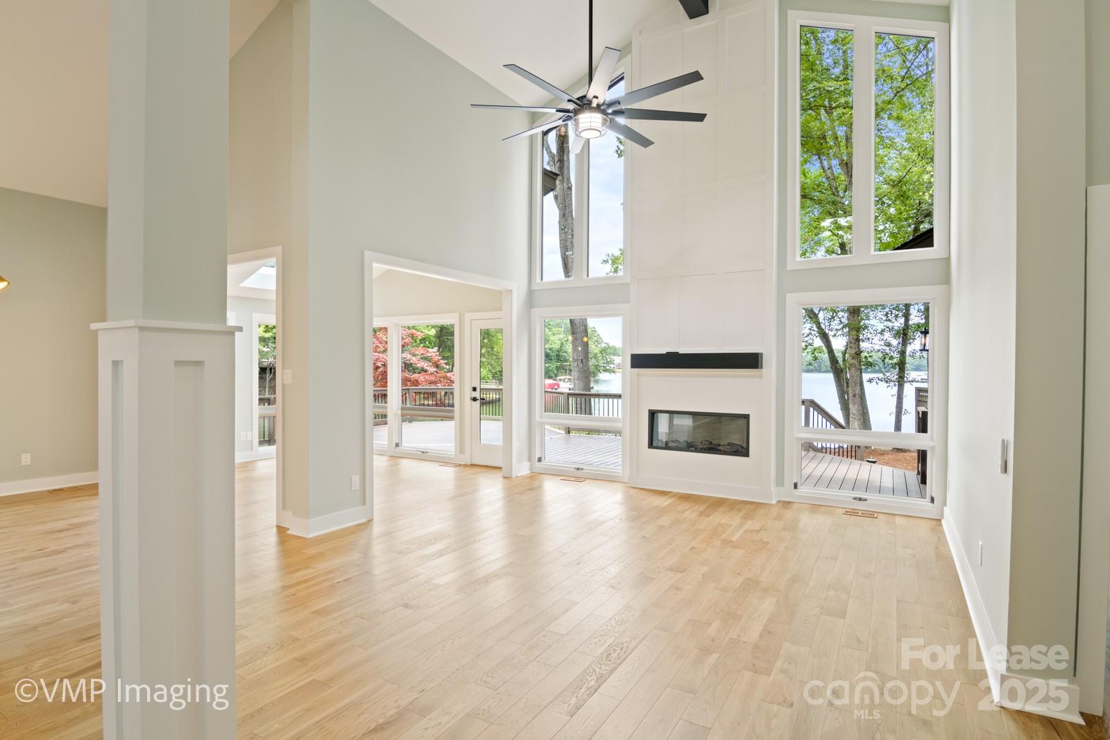 449 Windward Drive Davidson, NC 28036 - Photo 6 of 46 a view of a livingroom with a fireplace a ceiling fan and wooden floor