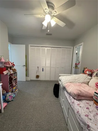 a bedroom with a bed and ceiling fan