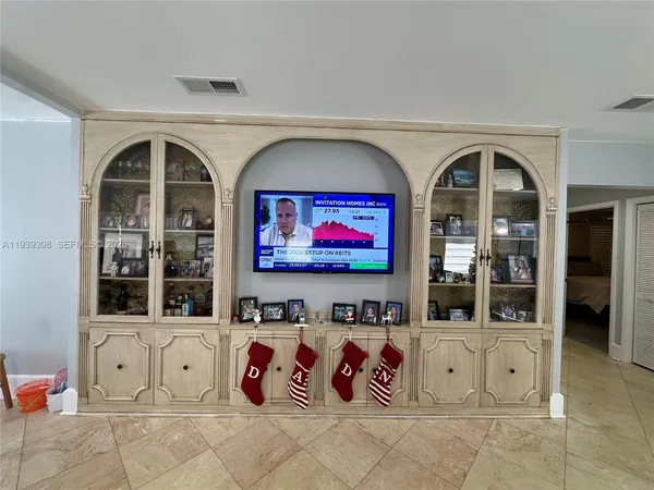 a living room with furniture a flat screen tv and a floor to ceiling window