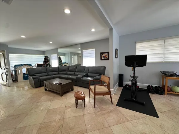 a living room with furniture a flat screen tv and a large window
