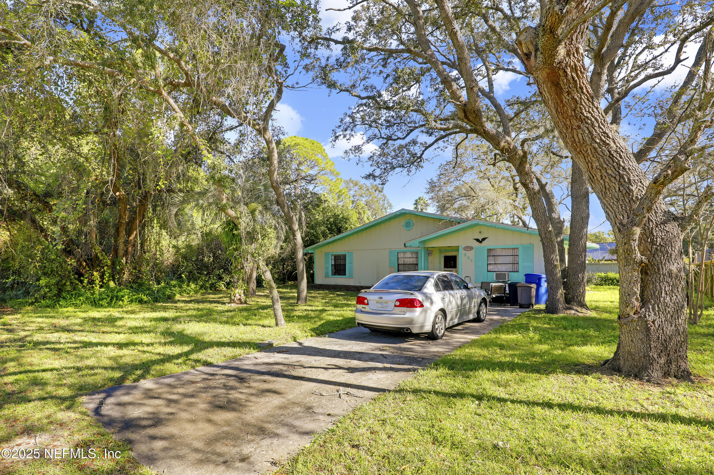 229 Bonita Road St. Augustine, FL 32086 - Photo 9 of 9 a front view of a house with a garden and trees