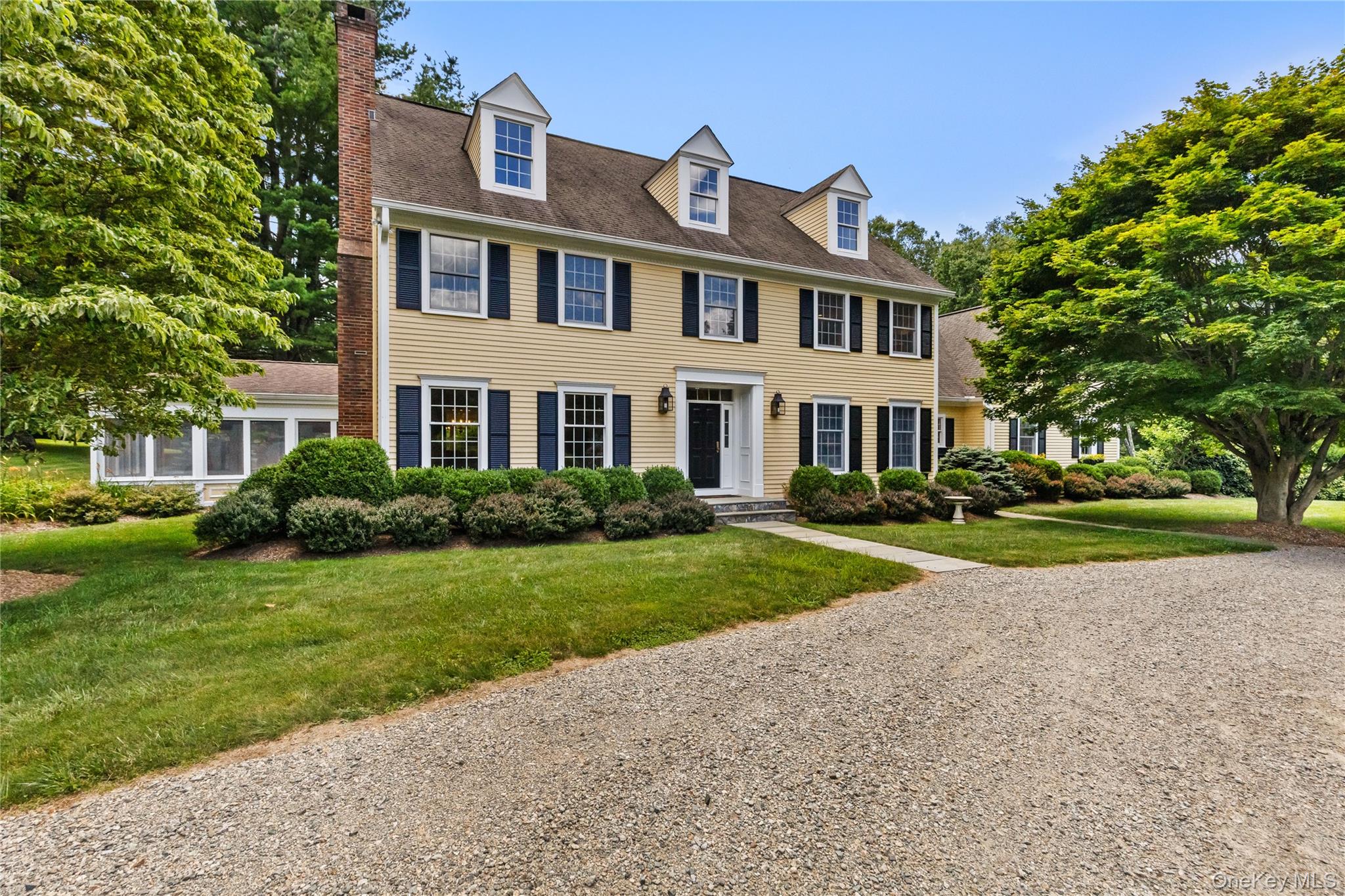 a front view of a house with yard and green space