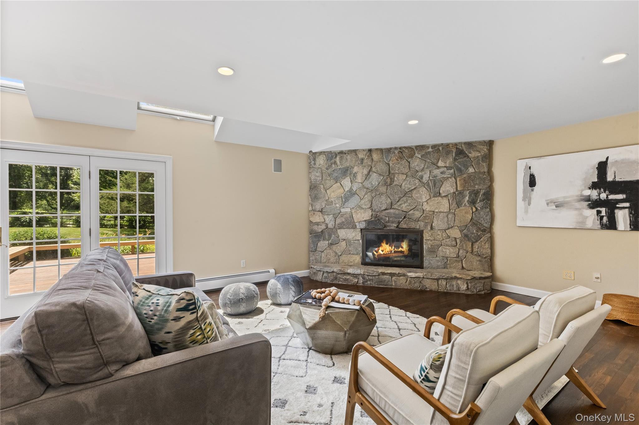 175 Finch Road North Salem, NY 10560 - Photo 15 of 44 Living area featuring wood finished floors, a stone fireplace, a baseboard radiator, and recessed lighting