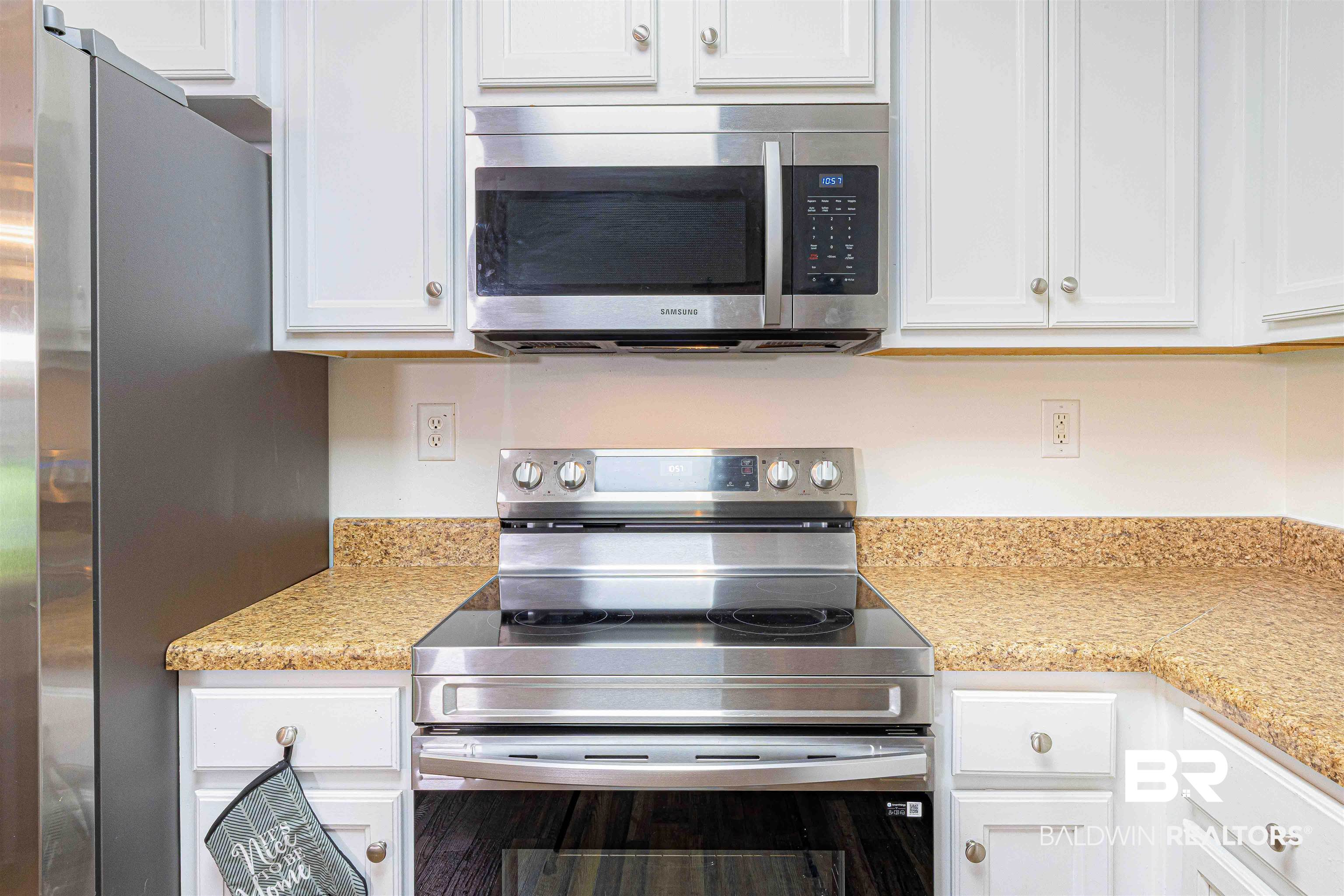18675 Explorer Drive Loxley, AL 36551 - Photo 12 of 42 Kitchen with appliances with stainless steel finishes, white cabinets, and light stone countertops