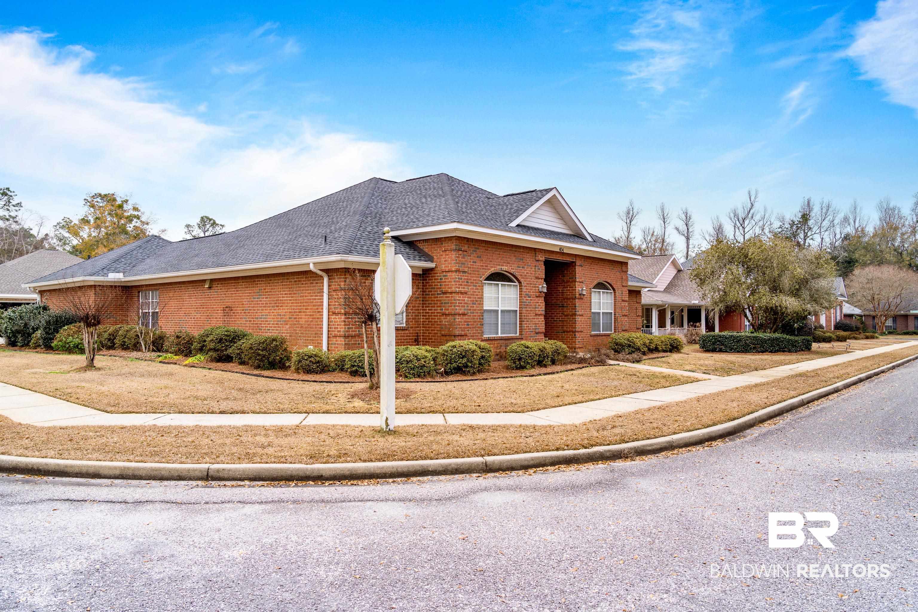404 Savannah Lane Foley, AL 36535 - Photo 2 of 29 View of front of home featuring a shingled roof, a front lawn, and brick siding
